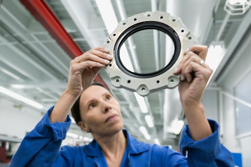female helicopter mechanic examining a disk